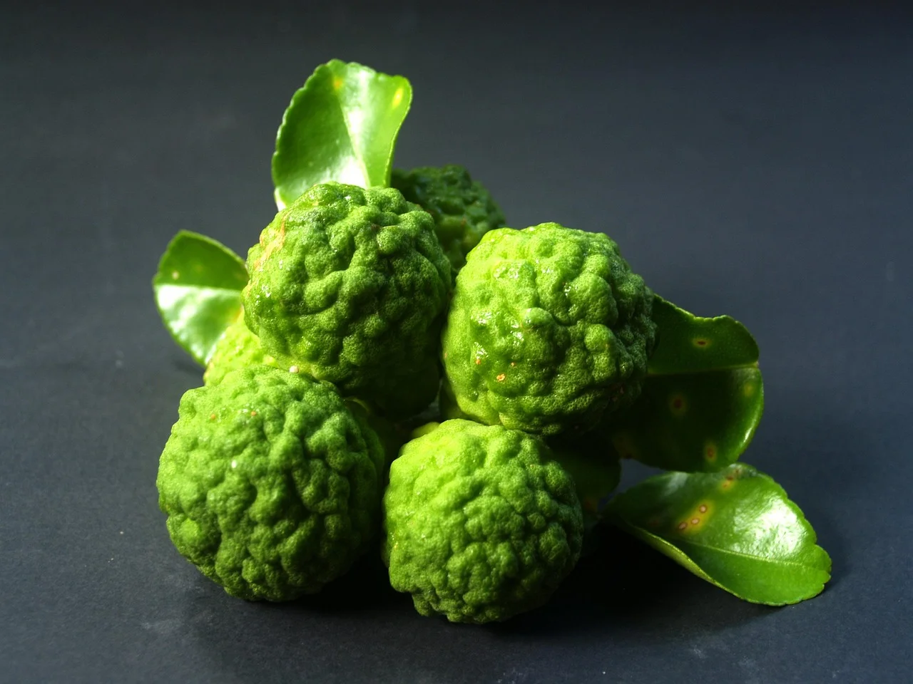Cuatro frutos de bergamota cítrica frescos con piel verde-amarilla